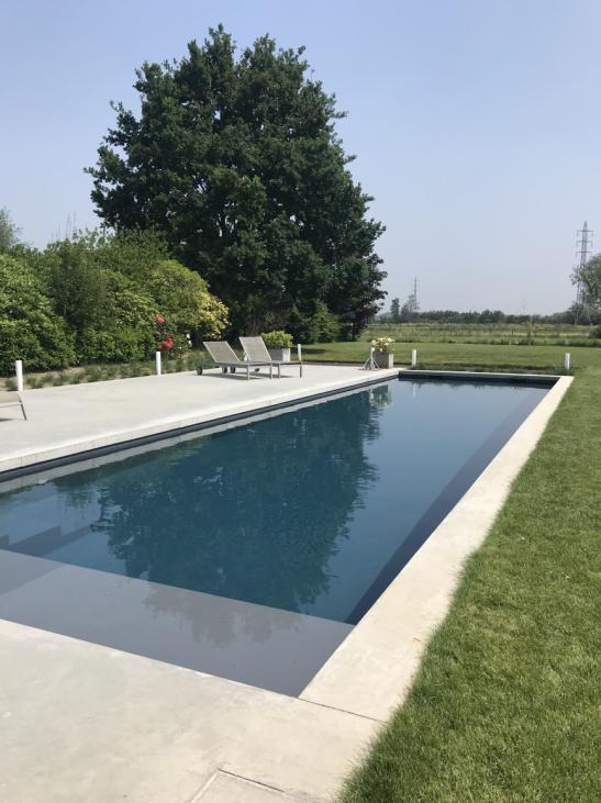 zwembad in de grond met moderne uitstraling en ligbedden