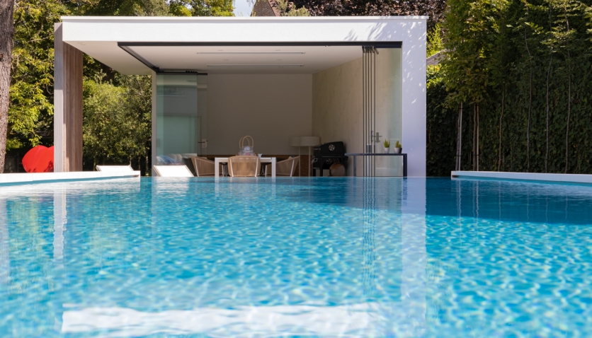 Zwembad in tuin met half open poolhouse