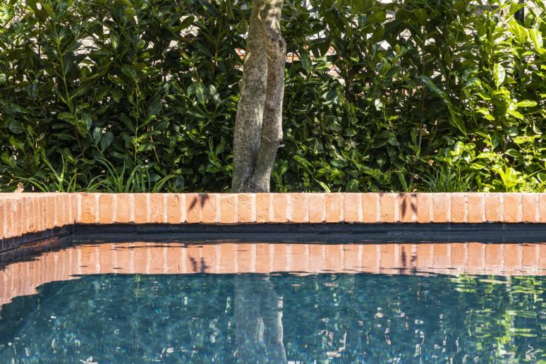 zwembad in tuin met rode baksteen detail