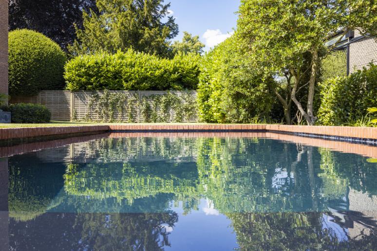 Zwembad in tuin met rode boordsteen